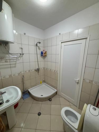 a bathroom with a toilet and a sink and a door at Matleo appartament in Golem