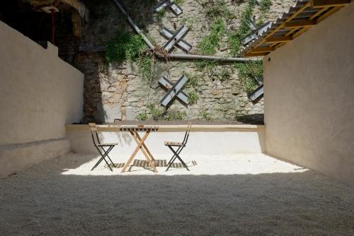 a table and two chairs in front of a wall at Appartement de l'UNESCO de Blaye- Spacieux & confort - 2 chambres in Blaye
