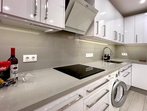 a kitchen with white cabinets and a counter top with a sink at Apartamento costero, los Abrigos. in Los Abrigos