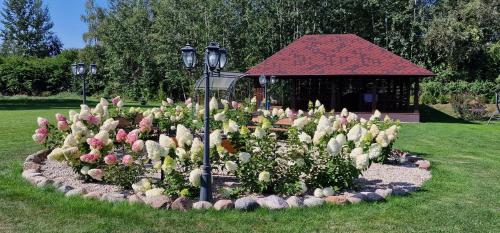 a garden of flowers in front of a gazebo at Sodyba "Kristina" in Biržai