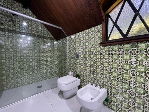 a bathroom with a toilet and a sink and a window at Alma Hotel in Campos do Jordão