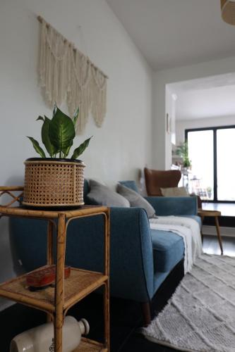 a living room with a blue couch and a plant at Stunning Walthamstow Village Flat in London