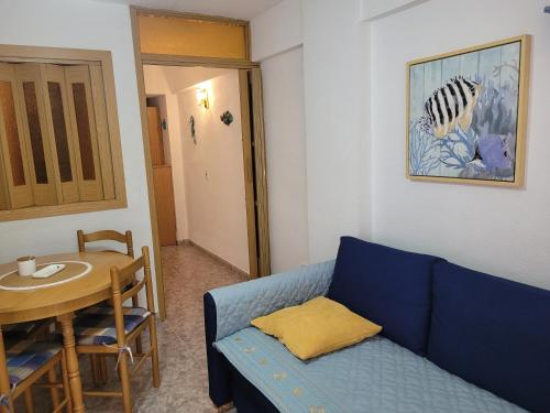 a living room with a blue couch and a table at TIGA muy cerca de la plaza de San Antonio in Cullera