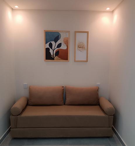 a couch in a room with two pictures on the wall at Flats Marina Maragogi in Maragogi