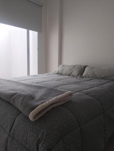 Una cama con una toalla al final. en Excelente departamento barrio constituyentes, en Santa Fe