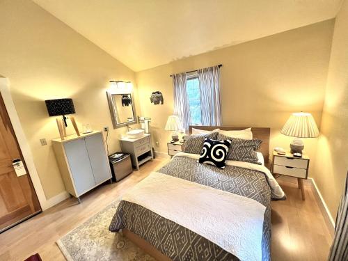 a bedroom with a large bed and a mirror at Bell In The Woods B&B in Seward