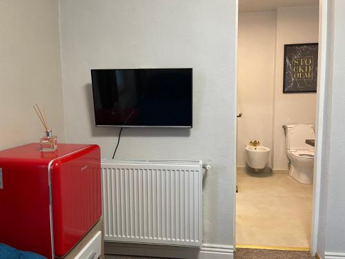 a bathroom with a television on a wall with a toilet at Milennium Apart Hotel in Bucharest