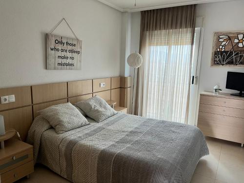 a bedroom with a bed and a large window at Duplex Torre la Sal Magic World La Tormesilla in La Estación