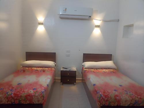 2 camas individuales en una habitación con calentador en NUBIAN MONALIZA guest house, en Asuán