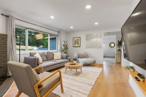 a living room with a couch and a tv at Peaceful Family Retreat Home w Firepit n Grill in Mountlake Terrace