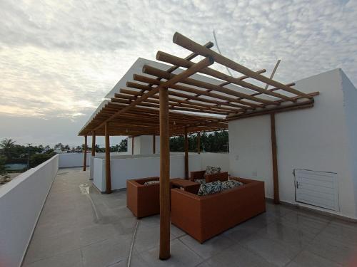 a wooden pergola on the roof of a building at Flats Marina Maragogi in Maragogi