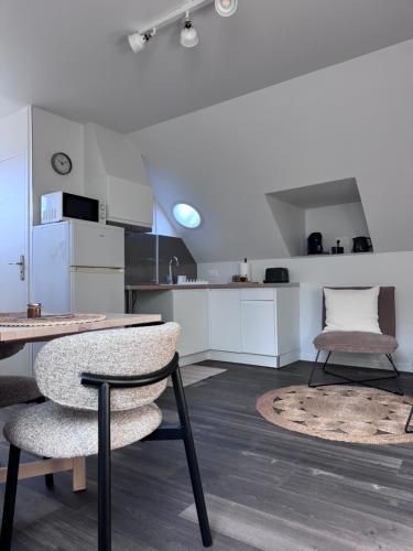 - une cuisine avec une table et deux chaises dans l'établissement A La Gravure d'Honfleur, à Équemauville