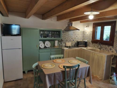 a kitchen with a table with chairs and a refrigerator at Cofano Bella Vista in Custonaci