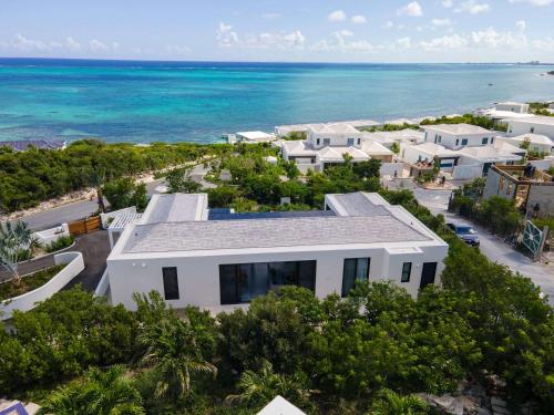 an aerial view of a white house on the beach at Villa Luna 4 Bedroom with Private Pool Oceanfront in Providenciales