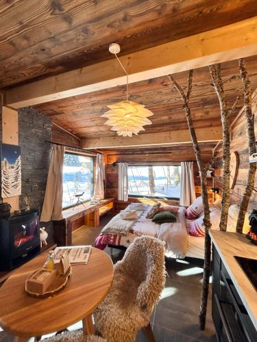 une chambre avec un lit et une table dans une pièce dans l'établissement Lys des Neiges Côté Forêt, à Les Déserts