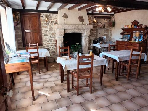 une salle à manger avec tables et chaises et une cheminée dans l'établissement Chambres d'hôtes Au bout du Monde, à Auderville
