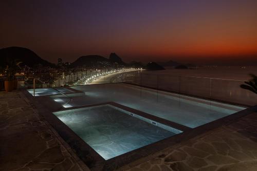 a swimming pool on the roof of a building at night at Rio Othon Palace in Rio de Janeiro