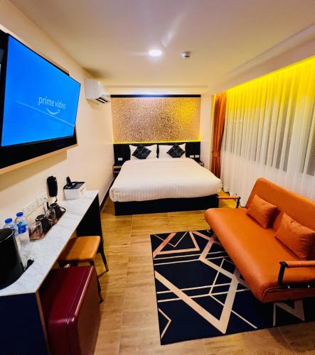 a hotel room with a bed and a tv at Emiri Hotel - Nana Bangkok in Bangkok