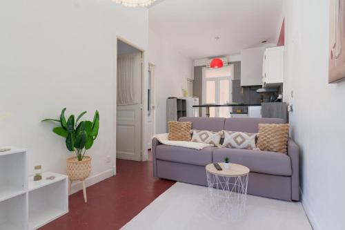 Il comprend un salon avec un canapé violet et une cuisine. dans l'établissement Le Cocon, Hypercentre Antibes - Netflix - Clim, à Antibes