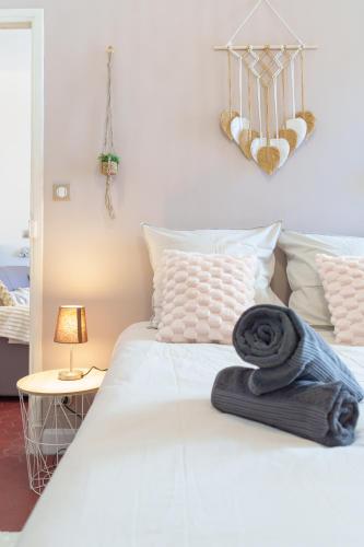 - un lit blanc avec une serviette noire dans l'établissement Le Cocon, Hypercentre Antibes - Netflix - Clim, à Antibes