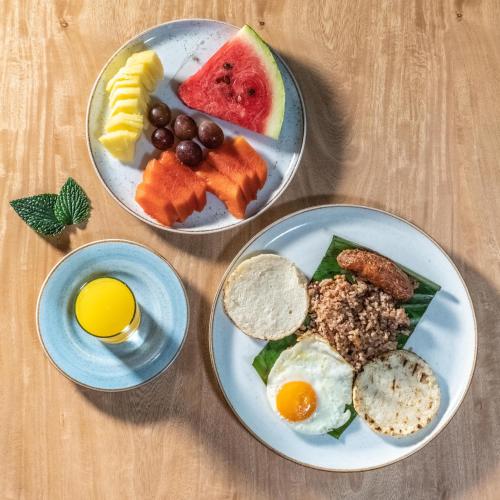 two plates of food with eggs and fruit on a table at Termales Santa Rosa De Cabal in Santa Rosa de Cabal