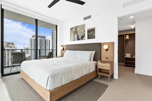 a bedroom with a large bed and a large window at Bayside Breeze - Downtown Luxury Tower in Miami