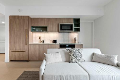 a living room with a white couch and a kitchen at Bayside Breeze - Downtown Luxury Tower in Miami