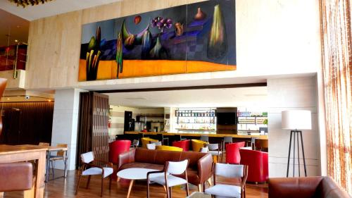 a restaurant with chairs and tables and a bar at Bogota Plaza Hotel in Bogotá