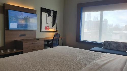 a bedroom with a bed and a desk and a television at Holiday Inn Express & Suites - Charlotte - South End by IHG in Charlotte