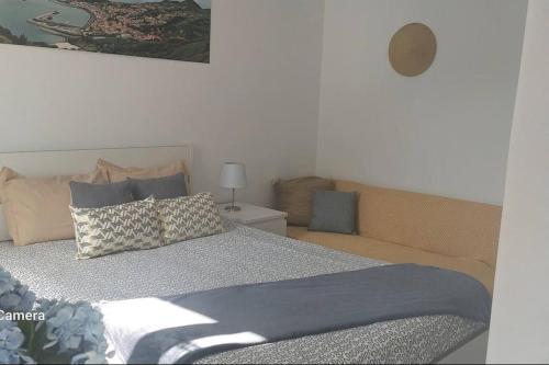 a bedroom with a bed with pillows on it at Uma horta na Horta in Horta