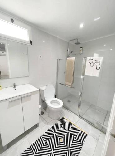 a white bathroom with a toilet and a shower at Aligus 2 Uma Horta na Horta, Faial, Açores in Horta