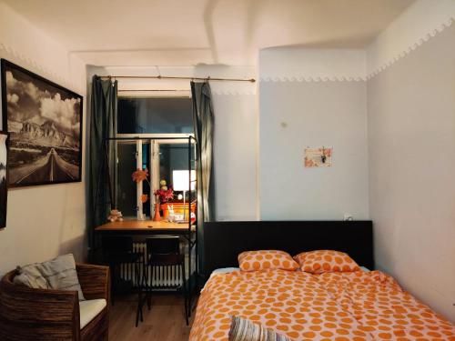 - une chambre avec un lit doté d'un couvre-lit orange et d'une table dans l'établissement 2StepsFromHelsinkiRailwayStation, à Helsinki