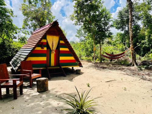 a colorful play tent with a bench and a hammock at Land of Promise - Reggae Escape in Zanderij