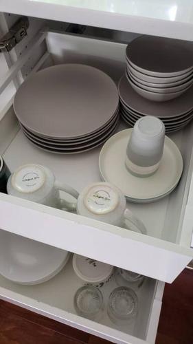 a drawer full of dishes and plates in a refrigerator at Charming Cape Cod Retreat in the Suburbs of NJ in Dumont