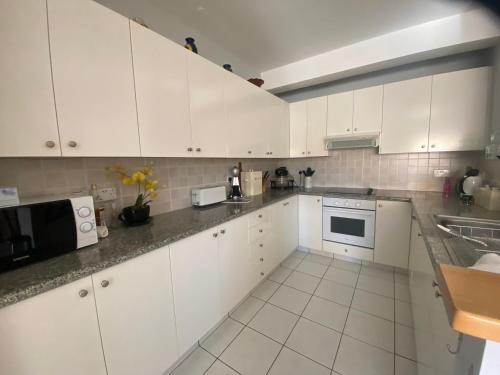 a white kitchen with white cabinets and appliances at William and Emily Apartment in Polis Chrysochous