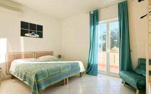 a bedroom with a bed and a chair and a window at Livingapple in Scauri