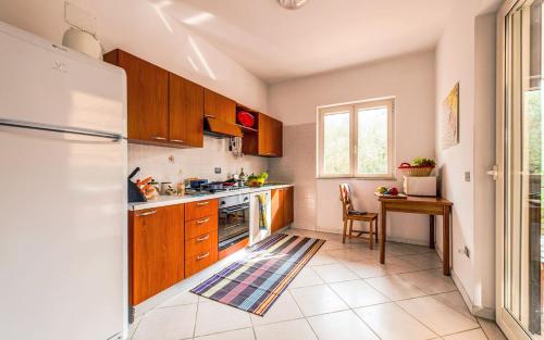 a kitchen with wooden cabinets and a table and a refrigerator at Livingapple in Scauri