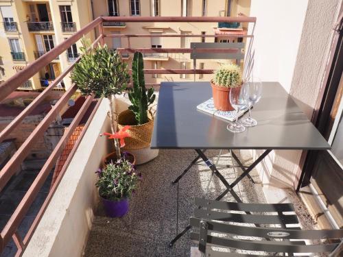 d'une table et de chaises sur un balcon orné de plantes. dans l'établissement Appartement proche de Libération avec balcon ensoleillé, à Nice