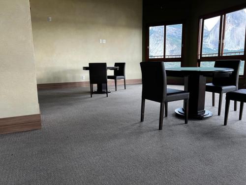 an empty room with tables and chairs and windows at Apart Hotel Vista Azul - Vista Pedra azul in Pedra Azul