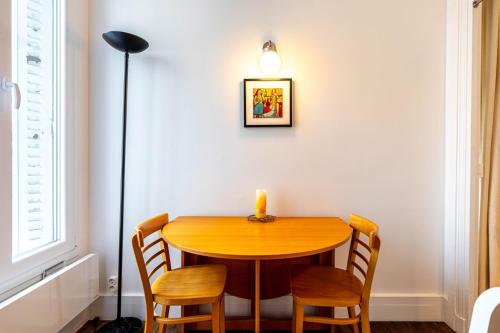 - une table à manger avec des chaises et une bougie dans l'établissement GuestReady - Espace Chic et Pratique pour 2, à Paris