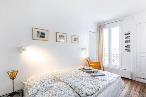 une chambre blanche avec un lit et une fenêtre dans l'établissement GuestReady - Espace Chic et Pratique pour 2, à Paris