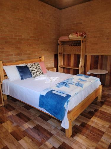 Chalés das cerejeiras في سانتو أنطونيو دو بينهال: غرفة نوم بها سرير في الغرفة