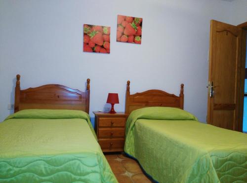 a bedroom with two beds and a lamp on a table at Pensión Amparo Las Hayas in Valle Gran Rey