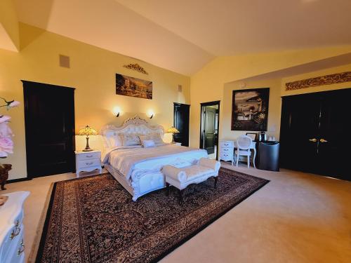 a large bedroom with a white bed and a rug at Villa Bellissimo FranTalia in Kelowna