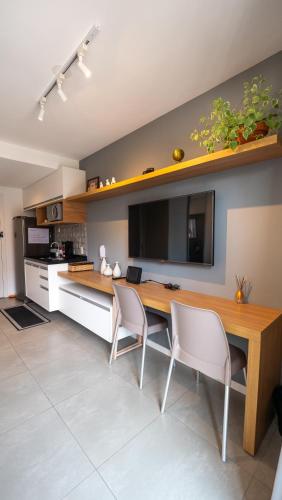 a kitchen with a wooden table and white chairs at Apezinho Moema in Sao Paulo