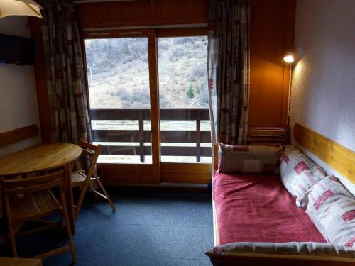 une chambre avec un lit, une table et une fenêtre dans l'établissement Appartement cosy 4 couchages à Méribel, bord de pistes - FR-1-355-61, à Méribel