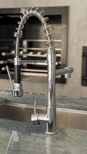 a kitchen sink with a chrome kitchen faucet at Lake's House - Piscina natural aquecida in Socorro