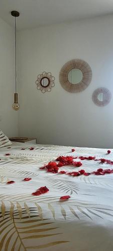 une chambre avec un lit avec des fleurs rouges dessus dans l'établissement Cottage Interieur Spa classé 4 étoiles - balnéo et sauna privatif, à Tannay