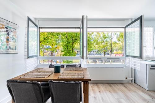 une salle à manger avec une table et une grande fenêtre dans l'établissement GuestReady - Séjour Élégant à Paris pour 6, à Paris