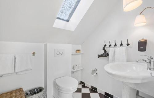 a white bathroom with a sink and a toilet at Sommerhus in Skanderborg
